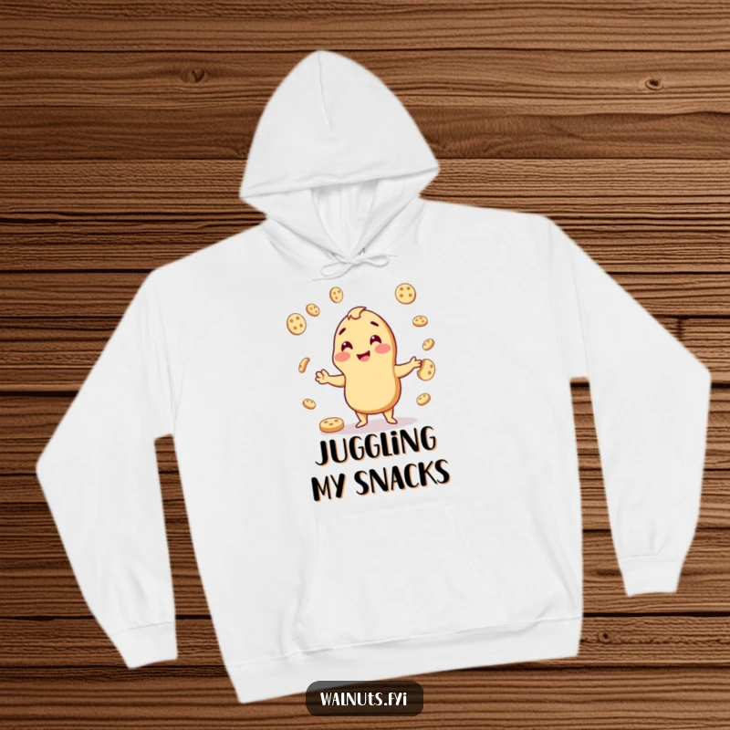 Funny hoodie depicting a happy cashew skillfully juggling cookie pieces, perfect for cozying up with snacks.